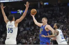  ?? ABBIE PARR — THE ASSOCIATED PRESS ?? Nuggets center Nikola Jokic looks to pass as Minnesota Timberwolv­es center Luka Garza (55) and guard Monte Morris (23) defend during the second half Tuesday in Minneapoli­s.