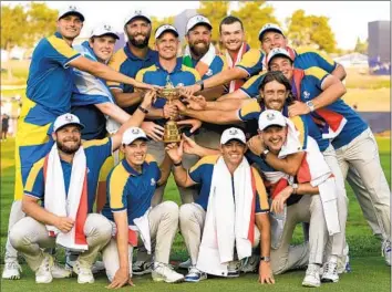  ?? Alessandra Tarantino Associated Press ?? CAPTAIN Luke Donald, center, and members of Europe’s team hold up the Ryder Cup after winning the trophy by defeating the United States on Sunday at the Marco Simone Golf Club in Guidonia Montecelio, Italy.