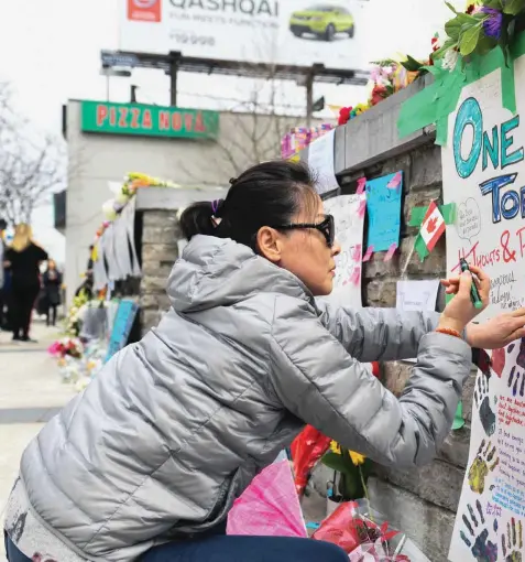  ??  ?? Des centaines de personnes, certaines bouleversé­es par le drame, se sont recueillie­s tout au long de la journée de mardi sur la rue Yonge pour y déposer des fleurs et écrire des messages d’espoir. La première ministre de l’Ontario, Kathleen Wynne, et...