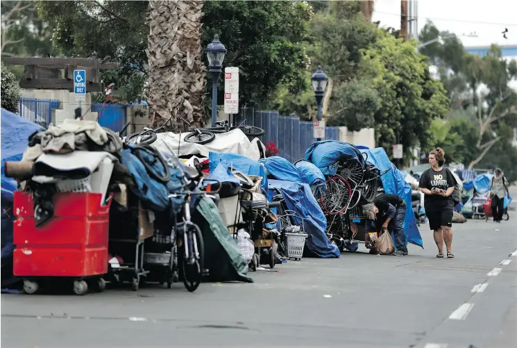  ?? PHOTOS: GREGORY BULL / THE ASSOCIATED PRESS ?? The number of people living outdoors in San Diego jumped more than 18 per cent this year. More than 400 makeshift shelters sprung up in the downtown area, where studio apartments go for around US$1,500 a month.