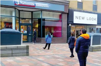  ??  ?? Distancing People observing guidelines while waiting to use the Nationwide bank in Stirling