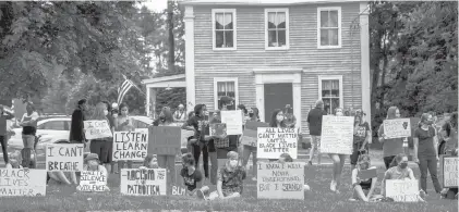  ?? KASSI JACKSON/HARTFORD COURANT ?? Protesters hold signs on the Tolland Green in a demonstrat­ion against police brutality on June 3, 2020, in Tolland.