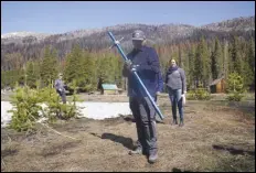  ?? ASSOCIATED PRESS ?? Holding the snowpack measuring tube, Sean de Guzman, manager of snow surveys and water supply for the California Department of Water Resources, looks down at the ground, Friday, where there would normally be snow to measure as he conducts the fourth snow survey of the season at Phillips Station near Echo Summit.