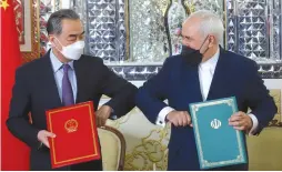  ?? (Majid Asgaripour/WANA via Reuters) ?? FOREIGN MINISTERS Mohammad Javad Zarif of Iran and Wang Yi of China bump elbows during the signing ceremony of a 25-year cooperatio­n agreement, in Tehran last month.