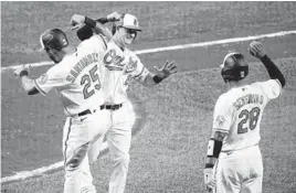  ?? JULIO CORTEZ/AP ?? The Orioles’ Austin Hays, center, is greeted near home plate after he drove in Anthony Santander (25) with a two-run home run off Royals starting pitcher Jackson Kowar in the third inning on Tuesday in Baltimore.