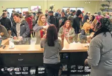  ?? CHRIS CHRISTO PHOTOS / HERALD STAFF ?? PACKED SHOP: Cultivate staff, above, help customers with their purchase in the packed store. Cultivate president Sam Barber, left, is pleased with the turnout.