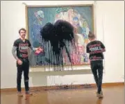  ?? AFP ?? Climate activists of the of Last Generation Austria group on Tuesday attacked Death and Life by artist Gustav Klimt in Vienna with a black, oily liquid and one (right) then glued himself to glass protecting the painting’s frame.