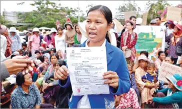  ?? PHA LINA ?? Oeung Sary (centre) and hundreds of other villagers attend a protest last month urging Kandal provincial authoritie­s to resolve their land dispute with tycoon Seang Chanheng.