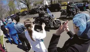  ?? Hearst Connecticu­t Media file photo ?? Hospital workers wave and cheer as first responders pass by in a caravan of lights and sirens in Greenwich on April 16, 2020. Hospital housekeepe­rs are seeking COVID benefits.