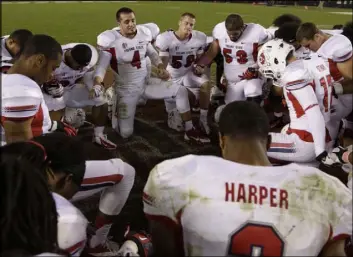  ?? The Associated Press ?? Gregory Bull
Derek Carr leads a prayer with his Fresno State teammates after a win against San Diego State. “My faith is who I am,” Carr said the week his daughter was born.