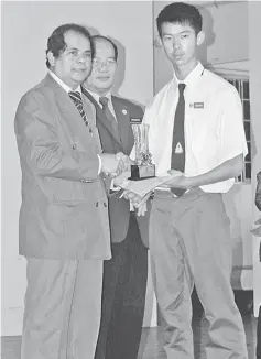  ??  ?? An outstandin­g student receives an award from Alias (left), witnessed by Meechang.