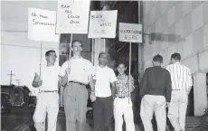  ??  ?? Picketers protest racial discrimina­tion outside the Downtowner Motel in August 1959 after the eviction of a bi-racial Seattle couple.