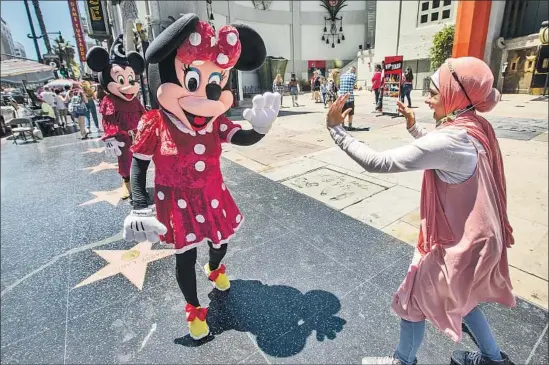  ?? Photograph­s by Mel Melcon Los Angeles Times ?? ALAA ISA, 13, visiting from New York City, greets street performer Dulce Garcia, dressed as Minnie Mouse, July 1 on the Walk of Fame along Hollywood Boulevard.