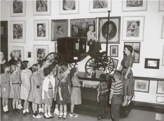  ?? UTSA Special Collection­s ?? Children in 1959 look at Tom Thumb’s carriage in the Harry Hertzberg Circus Collection at the main public library. Black groups were welcomed in 1943, and the main library was integrated in 1949.