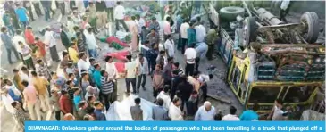  ?? AFP ?? BHAVNAGAR: Onlookers gather around the bodies of passengers who had been travelling in a truck that plunged off a bridge in Bhavnagar district, about 200km from Ahmedabad in India’s western Gujarat state yesterday. —