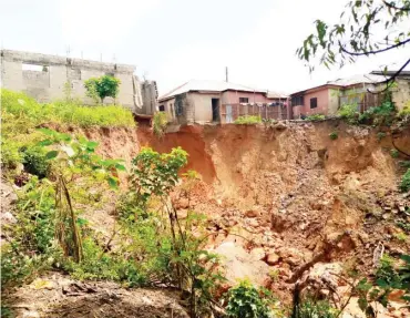  ??  ?? A gully erosion threatenin­g some houses in Anguwar Sarkin-Pawa in Abaji Area council