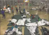  ?? U.S. Customs and Border Protection, via AFP / Getty Images ?? A government photo dated June 17 shows people who allegedly crossed the border illegally in detention at a government facility.