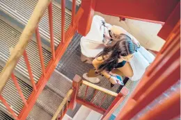  ??  ?? Emily Saracino, of Valley Stream, New York, makes her way up four flights of stairs while moving into her dorm room at the Towers residence halls on the Uconn campus at Storrs on Friday.