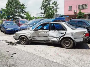  ??  ?? Aftermath: Some of the cars damaged by the lorry driver during the chase. (Left) Policemen pursuing the lorry attempting to shoot its tyres.