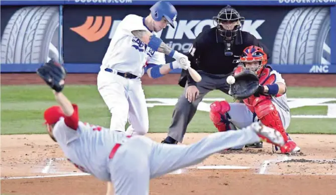  ?? AP ?? LOS ANGELES: Los Angeles Dodgers’ Yasmani Grandal, upper left, hits a solo home run as St Louis Cardinals starting pitcher Lance Lynn, below, watches along with catcher Yadier Molina, right, and home plate umpire Pat Hoberg during the first inning of a baseball game, Tuesday, in Los Angeles.—