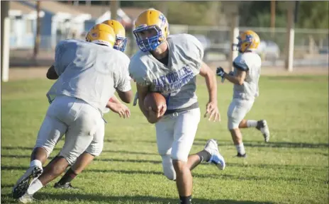  ?? VINCENT OSUNA PHOTO ?? Brawley Union High’s quarterbac­k Casey Kline runs the ball during their team practice in Brawley on Tuesday evening.