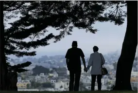  ?? AP PHOTO/JEFF CHIU, FILE ?? FILE- A man and woman walk under trees down a path at Alta Plaza Park in San Francisco. People in the final stretches of their working years feel less prepared to successful­ly age in their own homes than those who are 65and older and already likely to have shifted into their retirement years. That age gap is among the key findings of The Associated PRESS-NORC Center for Public Affairs poll.