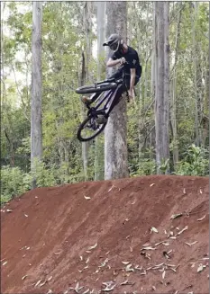  ??  ?? Makawao resident Patrick Doster, 20, takes off on the Akamai Track in the Kahakapao Recreation­al Area of Makawao Forest Reserve on Tuesday.