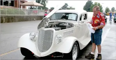  ?? PHOTOS BY LYNN KUTTER ENTERPRISE-LEADER ?? Tommy Easterling of Farmington dries his 1934 Ford 3 Window Coupe following a downpour Saturday morning at the annual Cardinal Car Classic in Farmington. Easterling and his wife, Marie, won Best of Show and People’s Choice for their coupe. The vehicle...