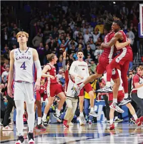  ?? Michael Reaves/Getty Images ?? Anthony Black, left, embraces Davonte Davis, who scored 21 of his game-high 25 points in the second half, after Arkansas prevailed against Kansas on Saturday.