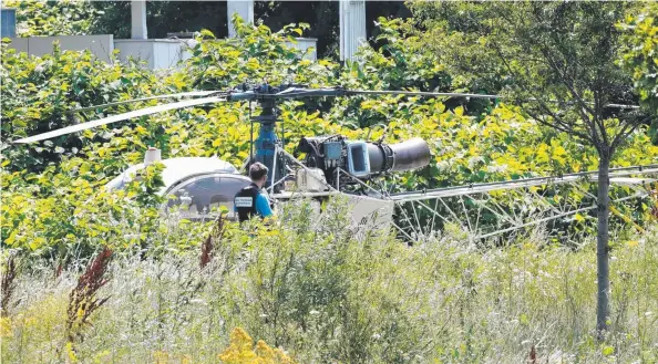  ?? Picture: AFP ?? DAREDEVILS: Police inspect the helicopter used by bank robber Redoine Faid (inset, left) during his escape from the Sud-Francilien prison (inset, right) near Paris at the weekend.