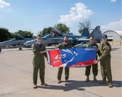  ?? PHOTO : IMAGERIE SDT CHAPUT ?? Le commandant de la FOA, le lcol Stephen Latwaitis (au milieu, à gauche), et l’adjudant Stephane Couturier (au milieu, à droite) posent avec le drapeau du 425e Escadron d’appui tactique en compagnie de deux pilotes de CF-18 de l’escadron qui viennent de se joindre à la mission, à la base aérienne Mihail Kogalnicea­nu (MK) en Roumanie, le 26 juillet.