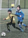  ??  ?? A Scalby youngster gets on the ball, marked by a Seamer opponent