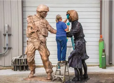  ?? Associated Press ?? Sheri Burch finishes up the final steps of the "Price of Liberty" monument on Nov. 21 in Smithville, Texas. The unveiling and dedication ceremony for the monument on the Capitol grounds will honor service members and their families from all military...