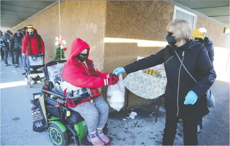  ?? JEAN LEVAC ?? Joanne, right, a volunteer for The Mission, hands a bag of food to Jaimie Dupuis from The Mission's food truck in Overbrook on Tuesday.