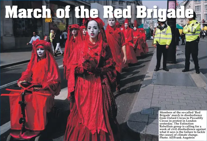  ?? Photo: AP/Frank Augstein ?? Members of the so-called ‘Red Brigade’ march in disobedien­ce from Oxford Circus to Piccadilly Circus in protest in London yesterday. The Extinction Rebellion group is calling for a week of civil disobedien­ce against what it says is the failure to tackle the causes of climate change.
