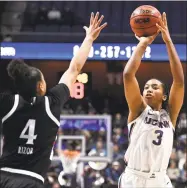  ?? Jessica Hill / Associated Press ?? UConn’s Megan Walker (3) shoots over Cincinnati’s Angel Rizor (4) during the first half of Monday’s AAC tournament final at Mohegan Sun Arena in Uncasville.