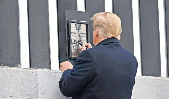  ??  ?? Donald Trump signs a plaque as he tours a section of the border wall in Alamo, Texas. In his first public appearance since the Capitol riots, the president said attempts to impeach him were ‘absolutely ridiculous’ and a ‘witch hunt’