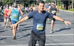  ?? KEITH GOSSE/THE TELEGRAM ?? Steve Antle runs through a spray of water on Topsail Road during the 90th running of the Tely 10 road race.