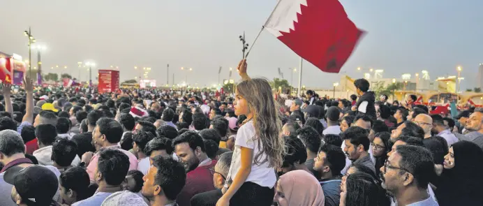  ?? ?? A girl waves a Qatari flag in a fan zone during the opening ceremony for the World Cup, prior to the Group A match between Qatar and Ecuador, in Doha, Qatar, Nov. 20, 2022.