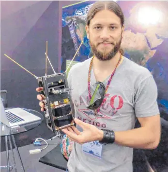  ?? FOTO: DPA ?? Der Informatik­er Gilles Nies aus Saarbrücke­n zeigt bei einem internatio­nalen Astronaute­n-Kongress in Mexiko den Satelliten GOMX-3.