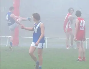  ??  ?? Thorpdale’s Callum Earle kicks a goal during the Blues’ 10-point win over Trafalgar in the under 18s which was played in pea soup fog conditions; Photograph­s: Paul Cohen