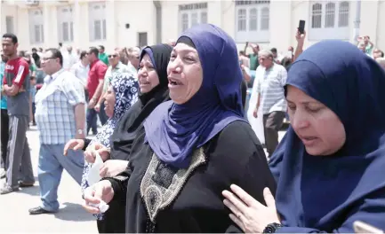  ??  ?? Egyptian women cry during the funeral of soldiers who were killed in the restive Sinai Peninsula in the north of Cairo on Saturday. (AFP)