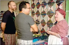  ?? PAT HARRIS ENTERPRISE-LEADER ?? Luis Murillo and John Lehnen of Fort Smith listened to Lillian McConnell describe the stories behind many of the quilts displayed at the quilt show held in a lower room in the Cane Hill College. Murillo and Lehnen said they enjoyed hearing about the...