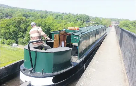  ??  ?? Mark Reuten keeps a watchful eye at the tiller as the canal boat crosses the stunning Pontcysyll­te Aquaduct in North Wales.