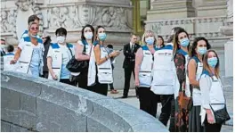  ?? RAPHAEL LAFARGUE/GETTY-AFP ?? People with protective masks stand outside the Grand Palais on Monday in Paris.