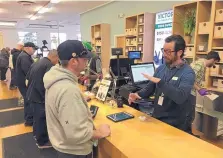  ?? TERRY CHEA/ASSOCIATED PRESS ?? Budtender Austin Pitts, right, assists a customer in the Harborside cannabis dispensary on Thursday in Oakland, Calif. The state legalized marijuana on Jan. 1.