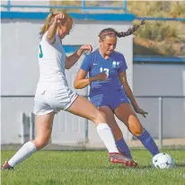  ?? GABRIELA CAMPOS/THE NEW MEXICAN ?? St. Michael’s Rachel Morgan and Los Alamos’ Aliya Richins fight for the ball during Tuesday’s game.