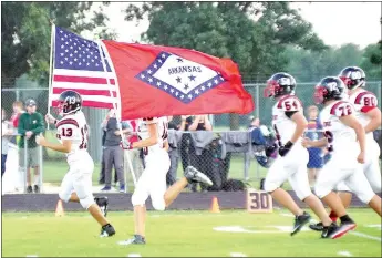  ?? Staff photograph­s by Randy Moll ?? The Pea Ridge Blackhawks entered the field Friday night in Gentry with the U.S. and Arkansas flags.