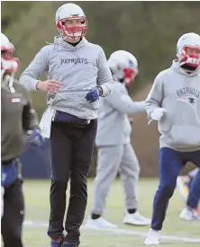  ?? STAFF PHOTO BY jOHn wilcOx ?? UP AND AT ’EM: Tom Brady gets loose at the start of yesterday’s practice in Foxboro.