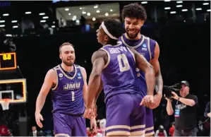  ?? (AP photo/mary Altaffer) ?? James Madison guard Xavier Brown (0), guard Noah Freidel (1) and forward Julien Wooden celebrate after James Madison defeated Wisconsin Saturday during a first-round college basketball game in the men’s NCAA Tournament in New York.